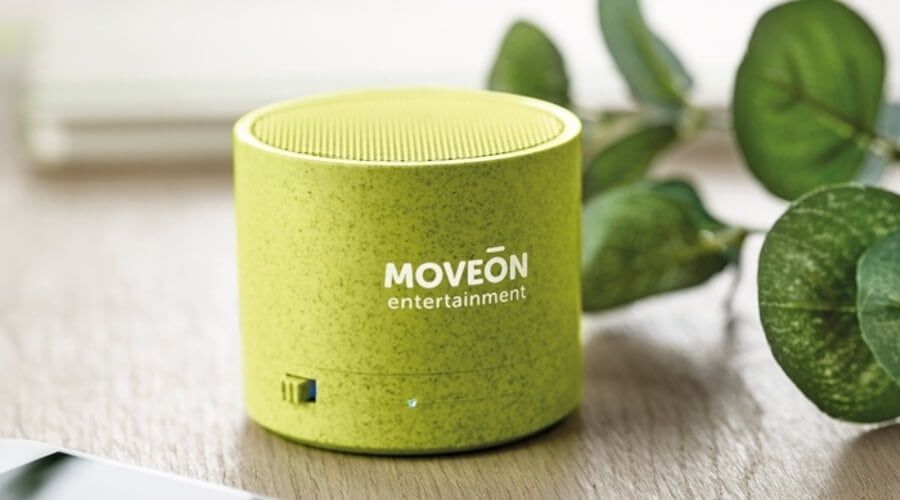 Grön profilhögtalare med MOVEON-logotyp på ett träbord