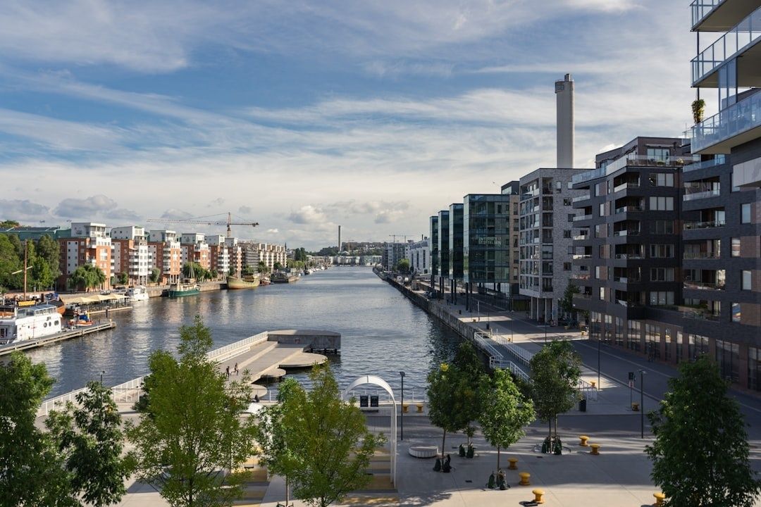 Svensk stadsdel vid vatten med moderna bostäder och kajpromenad
